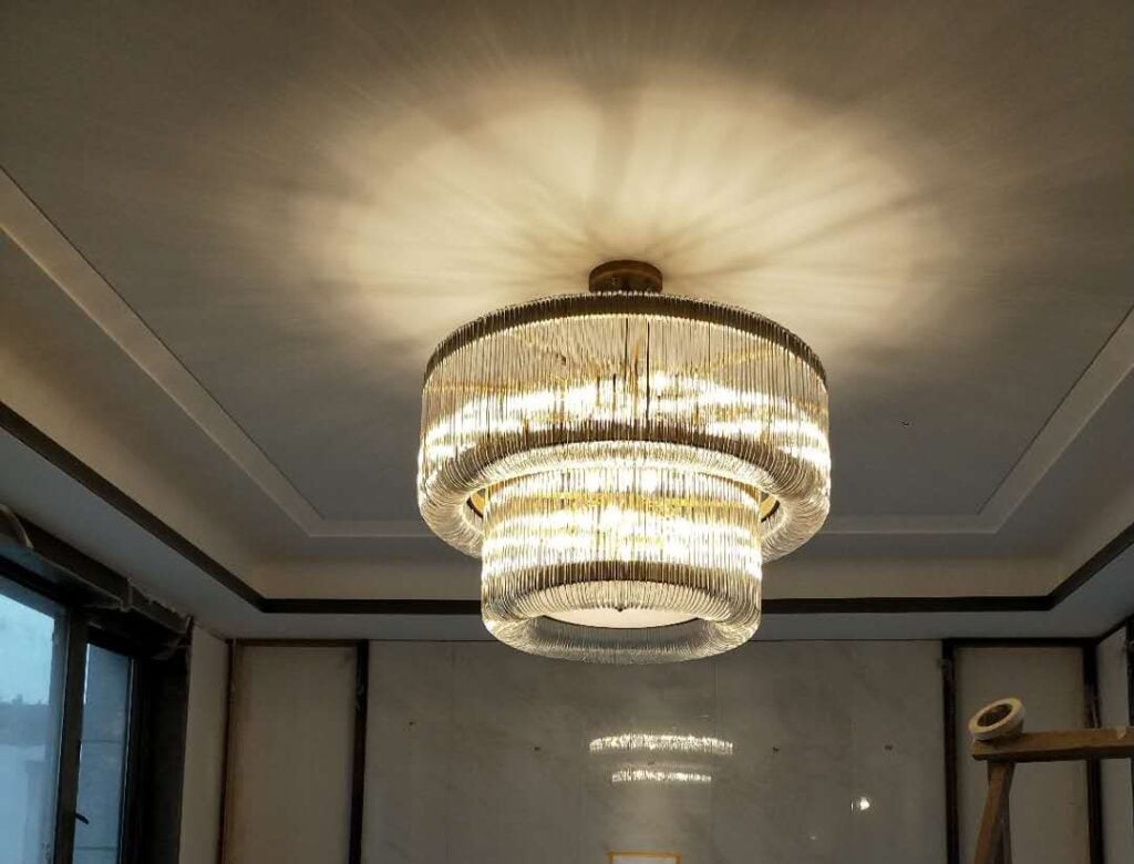 Decorative lighting is not only about brightness. In high-end interiors, it becomes part of the design language. A chandelier can define the center of a lobby. A pendant light can give rhythm to a restaurant. A wall lamp can add warmth to a corridor. A sculptural lighting fixture can turn an ordinary ceiling into a memorable design feature. For hotels, villas, restaurants, retail stores and luxury commercial spaces, decorative lighting helps shape how people experience the space. It can make an interior feel warmer, more luxurious, more artistic, more modern or more personal. This is why many project buyers choose bespoke decorative lighting instead of standard lighting fixtures. At Gusure Lighting, we create custom decorative lighting for global interior projects. Based in Zhongshan, China’s Lighting Capital, Gusure Lighting supports designers, architects, contractors, distributors and project buyers with custom chandeliers, pendant lights, ceiling lights, wall lamps, floor lamps, table lamps and artistic lighting fixtures. What Is Bespoke Decorative Lighting? Bespoke decorative lighting refers to lighting fixtures designed or customized for a specific interior concept. Unlike basic functional lighting, decorative lighting focuses on visual expression, atmosphere, material beauty and spatial identity. A bespoke decorative lighting project may include: Statement chandeliers for hotel lobbies Pendant lights for restaurants and bars Decorative wall lamps for corridors and guest rooms Sculptural ceiling lights for villas Artistic lighting installations for commercial spaces Custom fixtures for retail stores and showrooms Decorative lighting families for hotel rooms OEM/ODM lighting collections for brands and distributors The purpose is not simply to add a light fixture. The purpose is to create a design element that belongs to the space. Decorative Lighting vs Functional Lighting Functional lighting focuses on visibility. It helps people see, walk, work, read or complete tasks. Decorative lighting adds another layer: emotion, beauty and identity. In a professional interior project, both are needed. Lighting Type Main Purpose Common Examples Functional Lighting Provides necessary brightness Downlights, track lights, task lighting Decorative Lighting Adds visual value and atmosphere Chandeliers, pendant lights, wall lamps Accent Lighting Highlights specific areas or objects Spotlights, picture lights, display lights Ambient Lighting Creates general mood Cove lighting, diffused ceiling lights Decorative lighting often works together with these other lighting layers. A chandelier may not be the only source of light in a lobby, but it can become the most memorable element. Why Decorative Lighting Matters in High-End Interiors In luxury interiors, people do not only notice whether a space is bright. They notice how the space feels. Decorative lighting can influence: First impression Perceived luxury level Brand identity Interior style Visual rhythm Guest comfort Photo value Emotional atmosphere Space memorability For a hotel, decorative lighting can make the lobby more recognizable. For a restaurant, it can create a warmer dining mood. For a villa, it can express personal taste. For a retail store, it can make the brand environment feel more premium. This is why decorative lighting should be planned early in a project, not added at the end. Bespoke Decorative Lighting for Hotels Hotels use decorative lighting to create a complete guest experience. From the entrance to the room, lighting can help connect different spaces with a consistent design language. Common hotel applications include: Lobby chandeliers Reception pendant lights Restaurant decorative lighting Bar and lounge lighting Ballroom chandeliers Corridor wall lamps Guest room bedside lamps Suite ceiling lights Decorative lighting for lift lobbies For hotel projects, decorative lighting should be beautiful but also durable, safe and easy to maintain. A fixture used in a hotel must perform well over time, especially in public areas with frequent use. Gusure Lighting can customize decorative lighting according to hotel style, material direction, ceiling height, room layout and project quantity. Bespoke Decorative Lighting for Restaurants and Bars Restaurants and bars rely heavily on atmosphere. Decorative lighting can make the space feel intimate, stylish, dramatic or relaxed. Popular decorative lighting ideas for restaurants include: Pendant lights above dining tables Linear lights above bar counters Wall lamps for private dining rooms Chandeliers for fine-dining areas Glass pendant clusters for lounges Brass fixtures for warm luxury interiors Decorative ceiling lights for main dining zones The key is balance. The lighting should create mood without making the table too dark or causing glare. Warm color temperature, dimming options and proper fixture height are important. For restaurants, decorative lighting is also part of brand positioning. A casual café, luxury steakhouse, hotel restaurant and cocktail bar should not use the same lighting language. Bespoke Decorative Lighting for Villas and Private Residences Villas and luxury residences often need decorative lighting that feels personal and refined. The lighting should match the owner’s taste, interior material and room scale. Common applications include: Living room chandeliers Dining room pendant lights Staircase chandeliers Bedroom wall lamps Entrance hall lighting Lounge floor lamps Study room decorative lamps Custom ceiling fixtures In private residences, proportion is especially important. A fixture should match the size of the room and the height of the ceiling. A large chandelier can make a double-height living room impressive, while a soft wall lamp can make a bedroom more comfortable. Bespoke production allows the size, material, finish and light effect to be adjusted for each space. Bespoke Decorative Lighting for Retail and Brand Spaces Retail stores and showrooms use lighting to support brand experience. Decorative lighting can help a store feel more premium, more creative or more memorable. Suitable applications include: Feature chandeliers near entrances Pendant lights above display areas Decorative wall lamps for brand zones Custom lighting for fitting areas Sculptural lighting for flagship stores Artistic ceiling lights for showrooms Decorative lighting for luxury boutiques In retail design, decorative lighting should not distract from products. It should support product presentation and reinforce brand identity. For luxury retail spaces, material choice is very important. Brass, glass, crystal, smoked glass, matte black metal and alabaster-style materials can create very different brand impressions. How Decorative Lighting Builds a Design Theme A strong interior often has a repeated design language. Decorative lighting can help connect different areas through shape, finish, material or detail. For example: Design Theme Suitable Lighting Direction Modern Luxury Brass, glass, clean lines, warm LED Classic Elegance Crystal, gold finish, layered chandelier Natural Resort Alabaster-style material, bronze, soft curves Boutique Artistic Colored glass, sculptural forms, handmade details Minimalist Interior Linear fixtures, matte black, frosted glass Vintage Hospitality Antique brass, ribbed glass, warm wall lamps Contemporary Commercial Geometric shapes, stainless steel, architectural lighting This is where bespoke decorative lighting becomes valuable. Instead of forcing a standard fixture into the space, the lighting can be designed around the theme. Choosing Materials for Decorative Lighting Material selection affects both visual style and production cost. Different materials create different design effects. Material Design Effect Suitable Spaces Glass Transparent, artistic, flexible Hotels, villas, restaurants Crystal Sparkling, formal, luxurious Lobbies, ballrooms, banquet halls Brass Warm, premium, refined Hotels, restaurants, villas Stainless Steel Modern, clean, durable Commercial interiors, modern hotels Copper Artistic, warm, handcrafted Villas, lounges, boutique spaces Alabaster-Style Material Soft, natural, quiet luxury Resorts, bedrooms, lounges Fabric Shade Comfortable, residential, warm Guest rooms, suites, bedrooms Acrylic Lightweight, flexible, modern Large installations, commercial projects Many decorative lighting fixtures combine several materials. A glass and brass pendant light can feel warm and elegant. A crystal and stainless steel chandelier can feel grand and modern. An alabaster-style wall lamp with bronze metal can feel soft and premium. Surface Finish and Color Matching The surface finish of a lighting fixture should match the interior material palette. A wrong finish can make even a good design feel disconnected. Common finish options include: Brushed brass Antique brass Champagne gold Polished gold Matte black Bronze Chrome Brushed nickel Stainless steel Custom painted finish When choosing a finish, consider nearby materials such as door handles, furniture legs, wall panels, marble, wood veneer and metal trim. For example, brushed brass works well with warm marble and wood. Matte black works well in modern interiors. Bronze fits deeper, more atmospheric spaces. Chrome works better in clean contemporary designs. Shape, Scale and Visual Rhythm Decorative lighting should match the shape and rhythm of the space. A round chandelier can soften a square room. A linear pendant can follow the length of a dining table. A cluster chandelier can add movement to a high ceiling. A wall lamp series can create rhythm along a corridor. Common decorative lighting shapes include: Round Linear Ring Branch Cluster Cascade Geometric Floral Leaf-inspired Sculptural Multi-drop Modular For large projects, repeated visual elements can create consistency. For example, a hotel may use the same brass finish across lobby chandeliers, restaurant pendants and corridor wall lamps. Decorative Lighting and Color Temperature The appearance of a decorative light depends strongly on color temperature. A beautiful fixture can feel wrong if the light color does not match the atmosphere. Color Temperature Feeling Suitable Applications 2700K Warm, intimate, luxury Restaurants, bedrooms, lounges 3000K Warm, clear, hospitality-friendly Hotels, villas, corridors 3500K Balanced, modern Retail stores, showrooms 4000K Clean, functional Work areas, display zones For luxury decorative lighting, 2700K to 3000K is often preferred because it creates warmth and comfort. For retail or display spaces, higher color temperature may be considered if product clarity is more important. Dimming is also useful in restaurants, bars, lounges and hotel public areas because the lighting mood may need to change between day and night. Custom Decorative Lighting Options Gusure Lighting can support different customization directions for decorative lighting projects. Custom Item Options Product Type Chandelier, pendant light, wall lamp, ceiling light, floor lamp, table lamp Application Hotel, villa, restaurant, retail store, showroom, commercial space Material Glass, crystal, brass, copper, stainless steel, alabaster-style material Finish Gold, brass, bronze, black, chrome, nickel, custom color Shape Round, linear, branch, cluster, cascade, sculptural Light Source LED, dimmable LED, warm white, neutral white, high CRI Size Diameter, height, width, drop length, modular layout Installation Suspended, wall-mounted, ceiling-mounted, recessed, track-mounted Branding OEM/ODM service, private label, project packaging Packaging Export carton, wooden crate, project labeling These options allow designers and buyers to develop lighting that fits both design needs and production reality. How to Plan Decorative Lighting for a Project Before ordering decorative lighting, project buyers should define the role of each fixture. Ask these questions: Is the fixture a focal point or a supporting element? Is the main purpose atmosphere, decoration or task lighting? What interior style should the lighting match? What materials are used nearby? What color temperature is required? Is dimming needed? What is the ceiling height? What size will look balanced? How will the fixture be installed? How will it be cleaned or maintained? Does the project need repeated fixture families? These questions help avoid choosing lighting only by appearance. A decorative fixture should also fit the real project conditions. Decorative Lighting Families for Large Projects For hotels, serviced apartments, restaurants and commercial spaces, buyers often need more than one fixture. A lighting family can keep the design consistent. A decorative lighting family may include: Main chandelier Matching pendant light Wall lamp Ceiling light Floor lamp Table lamp Corridor fixture Custom accent light For example, a hotel may use a large chandelier in the lobby, smaller pendant lights in the restaurant, wall lamps in corridors and table lamps in guest rooms. These fixtures do not need to be identical, but they can share the same finish, glass style or design detail. This creates a more professional and unified interior. Common Mistakes in Decorative Lighting Selection Decorative lighting can improve a project, but poor selection can create problems. Choosing Only by Style A fixture may look good in a photo but may not fit the actual ceiling height, room size or installation condition. Ignoring Light Output Some decorative fixtures look beautiful but do not provide enough usable light. They should be combined with functional lighting if needed. Using Too Many Different Finishes Too many finishes can make a space feel messy. It is better to keep a controlled material palette. Making the Fixture Too Small In large spaces, small decorative lighting may disappear visually. Forgetting Maintenance Hotels and commercial spaces need fixtures that can be cleaned and maintained over time. Not Considering Packaging Fragile or large decorative fixtures require strong packaging for international shipping. How Gusure Lighting Supports Bespoke Decorative Lighting Projects Gusure Lighting supports decorative lighting projects from concept discussion to production. Our process usually includes: Understanding the project space and design direction Reviewing reference images or drawings Discussing fixture type, material and finish Evaluating size, structure and installation method Confirming light source and color temperature Providing quotation and production timeline Producing samples or mock-ups when needed Managing production and quality inspection Preparing export packaging and delivery This process helps turn creative lighting ideas into manufacturable and project-ready fixtures. Information Needed for a Decorative Lighting Quote To request a quotation from Gusure Lighting, prepare the following details if available: Project type Application space Product type Quantity Reference images Interior drawings or renderings Target size Ceiling height Material preference Finish requirement Light source requirement Color temperature Dimming requirement Installation method Destination country Project timeline OEM/ODM or branding needs You do not need to have every detail ready at the beginning. Gusure Lighting can help review the concept and suggest practical customization options. Why Choose Gusure Lighting for Bespoke Decorative Lighting? Gusure Lighting focuses on high-end custom lighting solutions for hotels, villas, restaurants, retail stores and commercial interiors. We combine decorative design understanding with practical manufacturing support. B2B buyers choose Gusure Lighting because we provide: Bespoke decorative lighting Custom chandeliers Custom pendant lights Decorative wall lamps Ceiling lights and floor lamps Artistic lighting fixtures OEM/ODM lighting service Material and finish customization Project-based production Export-ready packaging Whether your project needs a statement chandelier, a decorative pendant series, matching wall lamps or a complete lighting family, Gusure Lighting can help develop a solution that fits your interior concept. Start Your Bespoke Decorative Lighting Project Bespoke decorative lighting helps hotels, villas, restaurants, retail spaces and commercial interiors become more memorable. It adds visual character, atmosphere and design identity to the space. At Gusure Lighting, we help global buyers develop decorative lighting based on reference images, drawings, materials, finishes, dimensions and project needs. Share your design concept with Gusure Lighting and start your custom decorative lighting project today. Request a Decorative Lighting Quote Send Your Lighting Concept Start Your Custom Lighting Project FAQ What is bespoke decorative lighting? Bespoke decorative lighting refers to custom lighting fixtures designed to add visual value, atmosphere and identity to a space. It can include chandeliers, pendant lights, wall lamps, ceiling lights and artistic lighting installations. What is the difference between decorative lighting and functional lighting? Functional lighting provides necessary brightness, while decorative lighting adds beauty, mood and design character. In high-end projects, both types usually work together. Can Gusure Lighting customize decorative lighting for hotels? Yes. Gusure Lighting can customize chandeliers, pendant lights, wall lamps, ceiling lights and other decorative fixtures for hotel lobbies, restaurants, guest rooms, corridors and public areas. What materials are commonly used in decorative lighting? Common materials include glass, crystal, brass, copper, stainless steel, aluminum, alabaster-style materials, acrylic and fabric shades. Is bespoke decorative lighting suitable for restaurants? Yes. Decorative lighting is widely used in restaurants and bars to create atmosphere, define dining areas and strengthen brand identity. Can decorative lighting be customized for villas? Yes. Villas can use custom chandeliers, pendant lights, staircase lighting, wall lamps and ceiling fixtures to match the interior style and room scale. Does Gusure Lighting support OEM and ODM decorative lighting? Yes. Gusure Lighting supports OEM/ODM decorative lighting services for lighting brands, distributors, designers, contractors and project buyers. What information is needed for a decorative lighting quote? You should provide product type, quantity, target size, application area, reference images, material preference, finish requirement, color temperature, installation method and project timeline. Can Gusure Lighting create a matching lighting family for a project? Yes. Gusure Lighting can help develop matching chandeliers, pendant lights, wall lamps, ceiling lights, floor lamps and table lamps with consistent materials, finishes and design details. Why choose Gusure Lighting for bespoke decorative lighting? Gusure Lighting is based in Zhongshan, China’s Lighting Capital, and provides custom lighting design support, OEM/ODM service, flexible project production and export-ready packaging for global projects.
